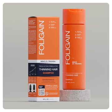 Syampu tiga tindakan FOLIGAIN untuk lelaki dengan 2% TRIOXIDIL, botol dan kotak jingga.