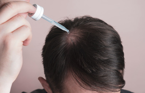 Rawatan rambut cecair disapu pada kulit kepala di bahagian ubun-ubun dengan penitis.