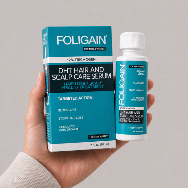 Tangan memegang botol dan kotak serum penjagaan rambut dan kulit kepala DHT FOLIGAIN, 60 mL.